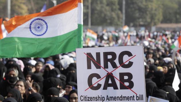 A demonstrator displays a placard during a protest against CAA, NRC, and NPR, at Azad Maidan, in Mumbai on Saturday.