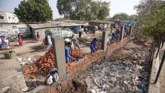 Workers construct a wall in front of a slum ahead of US President Donald Trump's visit, in Ahmedabad. US President Donald Trump said on Friday that he is looking forward to his two-day visit to India scheduled later this month. (PTI)