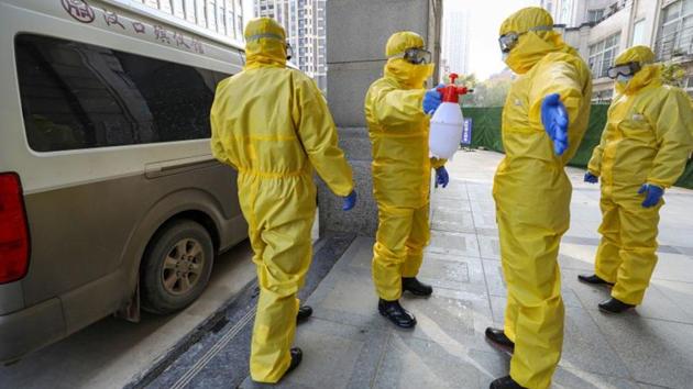 Funeral parlour staff members in protective suits help a colleague with disinfection after they transferred a body at a hospital in Wuhan. The new figures for total infections gave no sign the outbreak was nearing a peak, Adam Kamradt-Scott, an infectious diseases expert at the Centre for International Security Studies at the University of Sydney, told Reuters. (China Daily via REUTERS)