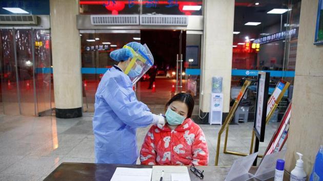 A nurse takes the temperature of a woman in the reception area of the First People's Hospital in Yueyang, near the border to Hubei Province, which is under partial lockdown. Outside China, more than 500 cases have been confirmed, mostly of people who travelled from Chinese cities, with five deaths in Japan, Hong Kong, the Philippines, France and Taiwan. (Thomas Peter / REUTERS)