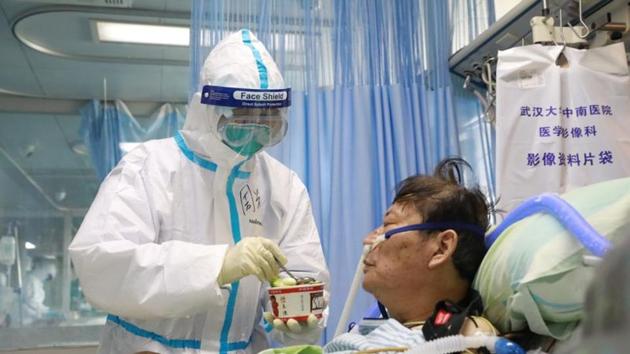 A nurse in a protective suit feeds a novel coronavirus patient inside an isolated ward at Zhongnan Hospital of Wuhan University, during the Lantern Festival, which marks the end of the Chinese Lunar New Year celebrations. (China Daily via REUTERS)