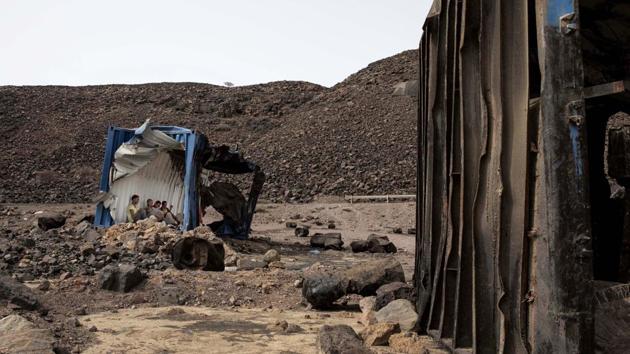 Mohammed Eissa, an Ethiopian farmer and migrants he met along the way, shelter inside a damaged shipping container on the side of a highway, near Lac Assal, Djibouti. “Patience,” Eissa told himself. He whispered it every time he felt like giving up. The sun was brutal, reflecting off the thick layer of salt encrusting the barren earth around Lac Assal, a lake 10 times saltier than the ocean. (Nariman El-Mofty / AP)