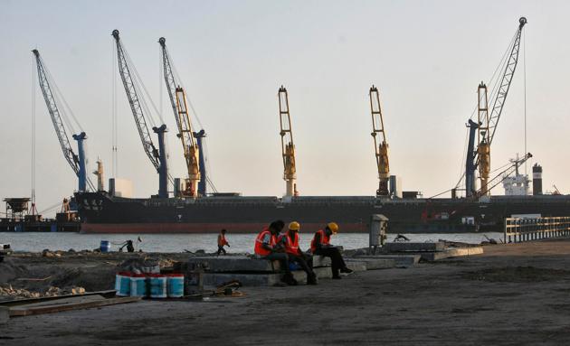 Worker rest in front of a cargo ship at a port in Gujarat.(Reuters File Photo)