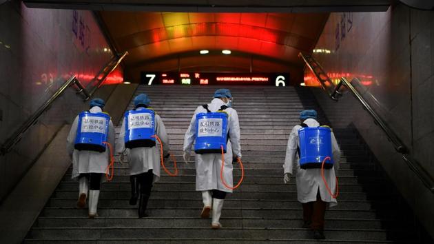 Workers with sanitizing equipment walk up a flight of stairs as they disinfect a railway station, in Kunming, Yunnan province. The biggest cluster of infections outside China has been on a cruise liner quarantined in a Japanese port. Seventy more infections were confirmed on board the Diamond Princess on Sunday, bringing the number of cases from the ship to 355. (Cnsphoto via REUTERS)