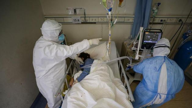 Medical workers in protective suits attend to a patient inside an isolated ward of Wuhan Red Cross Hospital in Wuhan. Image used for representational purpose only.(REUTERS)