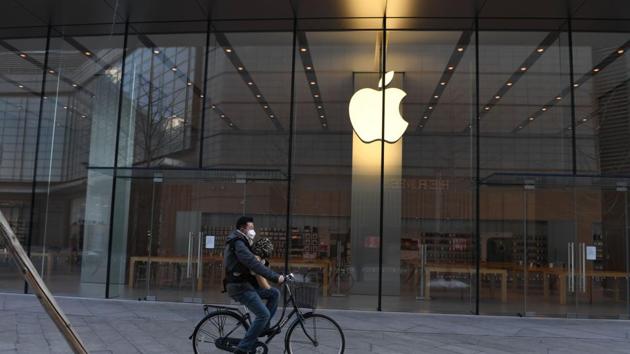 (FILES) In this file photo taken on February 8, 2020 a man cycles past a closed Apple store in Beijing. China accounted for 15% of Apple’s revenue, or $13.6 billion, last quarter, and supplied 18% of revenue in the year-ago quarter. (AFP FIILE) (FILES) In this file photo taken on February 8, 2020 a man cycles past a closed Apple store in Beijing. China accounted for 15% of Apple’s revenue, or $13.6 billion, last quarter, and supplied 18% of revenue in the year-ago quarter. (AFP FIILE)