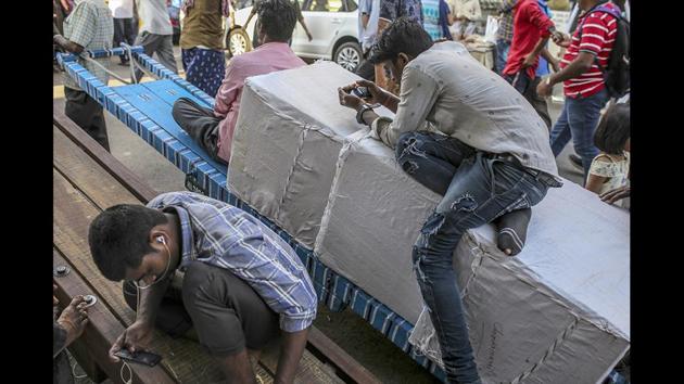 Workers use smartphones while sitting on carts in Mumbai. The government proposed these guidelines in December 2018 and asked for public comment. The Internet and Mobile Association of India, a trade group that counts Facebook Inc., Amazon.com Inc. and Alphabet Inc.’s Google among its members, responded that the requirements “would be a violation of the right to privacy recognised by the Supreme Court.” (Dhiraj Singh / Bloomberg)