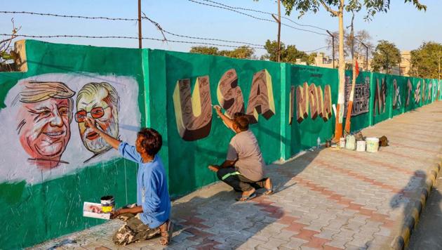 A man gives finishing touches to paintings of US President Donald Trump and Prime Minister Narendra Modi on a wall as part of a beautification along a route that Trump and Modi will be taking during Trump's upcoming visit, in Ahmedabad.(PTI Photo) A man gives finishing touches to paintings of US President Donald Trump and Prime Minister Narendra Modi on a wall as part of a beautification along a route that Trump and Modi will be taking during Trump's upcoming visit, in Ahmedabad.(PTI Photo)