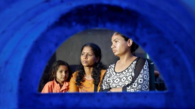 Aswathy Jwala (C), a social activist, who is on a hunger strike to oppose the building of a 400 metre long wall along a slum area, that authorities said was built as part of a beautification drive the roadshow’s route. (Amit Dave / REUTERS)