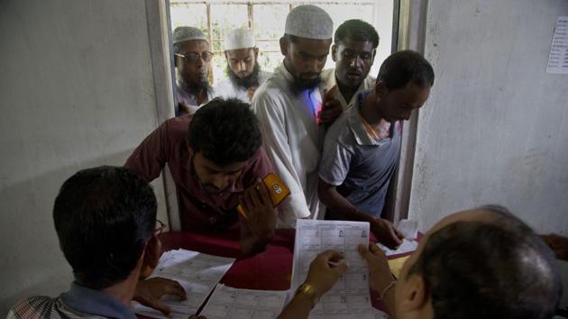 Villagers check for their names in the final NRC list in Buraburi village in Assam’s Morigaon district in this file photo.(AP)