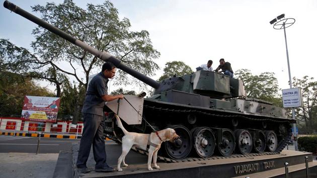 Members of a bomb disposal squad from Gujarat Police scan a tank on display outside an army camp, along the route of the roadshow. Ahmedabad Mayor Bijal Patel and Ahmedabad Municipal Corporation (AMC) officials held a meeting on Friday with representatives of social, cultural and religious organisations expected to take part in the roadshow. (Amit Dave / REUTERS)