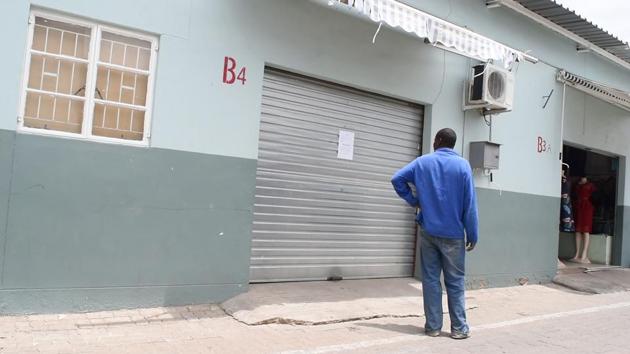 A man reads a letter to customers on the shutters of a closed shop in Windhoek’s Chinatown. As the fear of infection spreads, businesses are taking things into their own hands. A notice taped to a Chinese-owned shop spelled it out: Any merchant returning from China “must be quarantined for 14 days and keep the shop closed for that period”, stated the instructions signed by the Chinatown management. (Hildegard Titus / AFP)