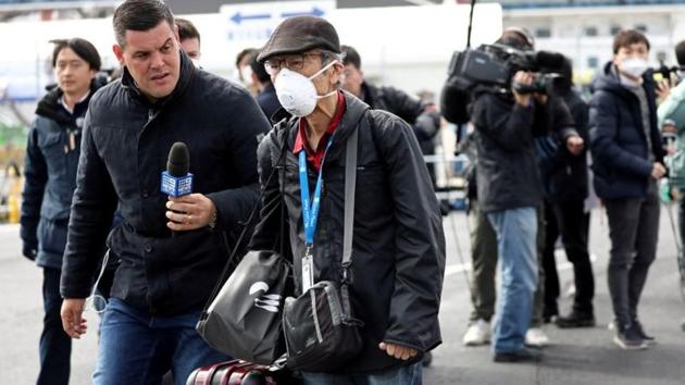 A member of the media approaches a passenger after he walked out from the cruise ship Diamond Princess at Daikoku Pier Cruise Terminal in Yokohama, south of Tokyo, Japan February 19, 2020. (REUTERS) A member of the media approaches a passenger after he walked out from the cruise ship Diamond Princess at Daikoku Pier Cruise Terminal in Yokohama, south of Tokyo, Japan February 19, 2020. (REUTERS)