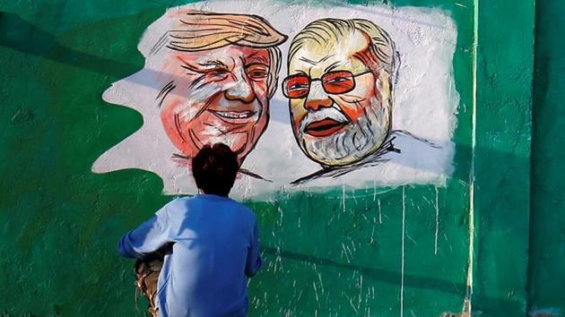 A man applies finishing touches to paintings of US President Donald Trump and Prime Minister Narendra Modi on a wall as part of a beautification along a route that Trump and Modi will be taking during Trump’s upcoming two day visit, in Ahmedabad. (Amit Dave / REUTERS)