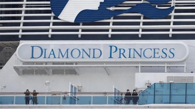 Masked passengers look on from on board the coronavirus-hit Diamond Princess cruise ship docked at Yokohama Port, south of Tokyo, Japan. (REUTERS)