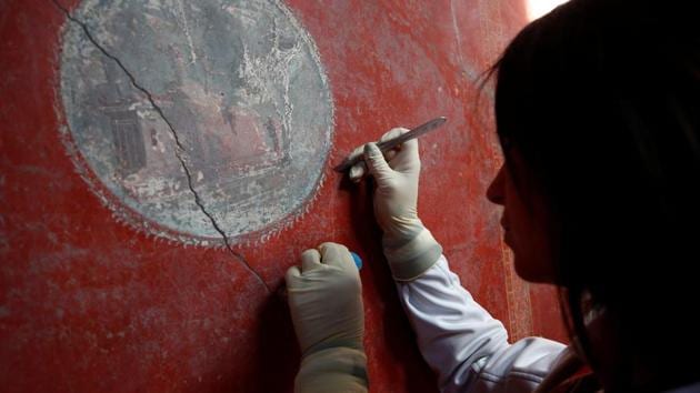 A restorer works on a fresco in the House of Lovers "Casa degli Amanti", one of three restored domus --family residences for the upper classes --reopened to the public at the archaeological site of Pompeii, Italy 40 years after it was severely damaged in 1980 by an earthquake. (Ciro De Luca / REUTERS)