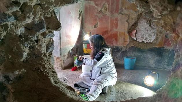 A restoration specialist working inside the House of Lovers. Though the bulk of the restoration work is now complete, director Osanna said running repairs will never truly be over. “It’s a city in ruins,” he said. “The attention we pay to it must never stop.” (Alexandria Sage / AFP)
