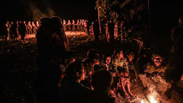 People gather by a camp-fire or warmth as Naga tribeswomen perform the overnight ceremony to bless the harvest. Dressed in black and wearing orange bead necklaces and palm leaf headbands, they rotated around a fire, hands held tightly and braving the cold bare armed. “This is the essence of our village and it brings us joy,” they chorused. (Ye Aung Thu / AFP)