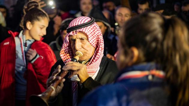 A Syrian man plays the mizmar, a traditional wind instrument, as he welcomes the Amuda women's team. Syrian society is still largely patriarchal and conservative but women enjoy greater gender equality in areas under Kurdish control. Hussein said she hopes football will continue to grow in her region. (Delil Souleiman / AFP)