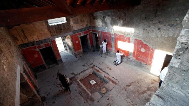 Archaelogists work on a fresco in the House of Lovers "Casa degli Amanti", one of three restored domus (ancient houses) reopened to the public at the archaeological site of Pompeii, Italy, February 18, 2020. REUTERS/Ciro De Luca (REUTERS)