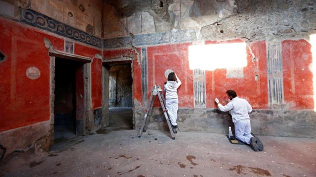Archaeologists work on a fresco in the House of Lovers "Casa degli Amanti",one of three restored domus (ancient houses) reopened to the public at the archaeological site of Pompeii, Italy, February 18, 2020. REUTERS/Ciro De Luca (REUTERS)