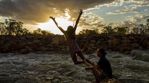 A girl jumps from rocks at Brewarrina Weir which overflowed on the weekend for the first time in years, as rain water from upstream flowed into the once dry river beds in Brewarrina, Australia. The influx of water at the weir has also brought back to life the heritage listed Aboriginal fish traps, also known as Baiame's Ngunnhu. (Jenny Evans / Getty Images)