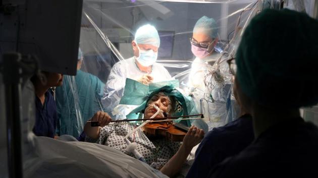 Dagmar Turner, 53, plays violin while surgeons remove her brain tumour at King's College Hospital in London, England. Doctors mapped her brain before the surgery to identify areas active when she played the instrument and those responsible for controlling language and movement. They then woke her mid-procedure to “ensure the surgeons did not damage any crucial areas”. (King's College Hospital via REUTERS)