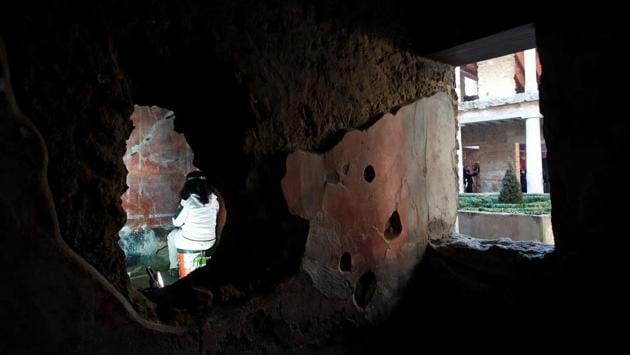 An archaelogist works on a fresco in the House of Lovers "Casa degli Amanti", one of three restored domus (ancient houses) reopened to the public at the archaeological site of Pompeii, Italy, February 18, 2020. REUTERS/Ciro De Luca (REUTERS)
