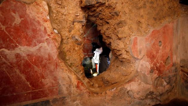 An archaelogist works on a fresco in the House of Lovers "Casa degli Amanti", one of three restored domus (ancient houses) reopened to the public at the archaeological site of Pompeii, Italy, February 18, 2020. REUTERS/Ciro De Luca (REUTERS)