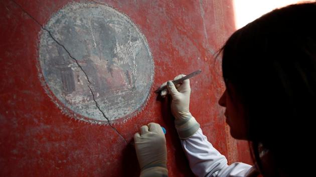 An archaelogist works on a fresco in the House of Lovers "Casa degli Amanti", one of three restored domus (ancient houses) reopened to the public at the archaeological site of Pompeii, Italy, February 18, 2020. REUTERS/Ciro De Luca (REUTERS)