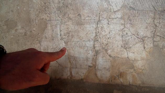 An archaeologist points to engravings on the wall of the House of Europe's Ship, "Casa della Nave Europa", one of three restored domus (ancient houses) that has reopened to the public at the archaeological site of Pompeii, Italy, February 18, 2020. REUTERS/Ciro De Luca (REUTERS)