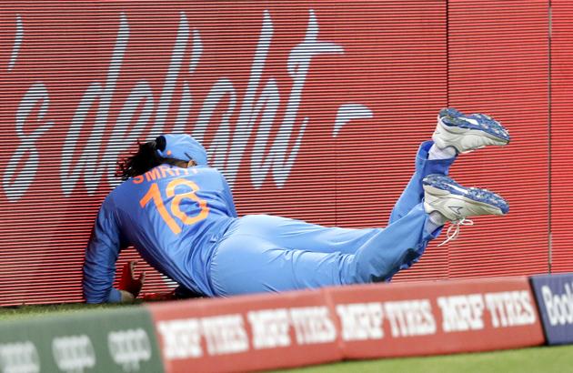 India's Smriti Mandhana crashes into the signage and hurts her left shoulder while fielding against Australia in the Women's T20 Cricket World Cup in Sydney. (AP)