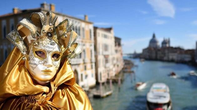 A reveller wearing a mask and a period costume takes part in the Venice Carnival in Italy. (Alberto Pizzoli / AFP)