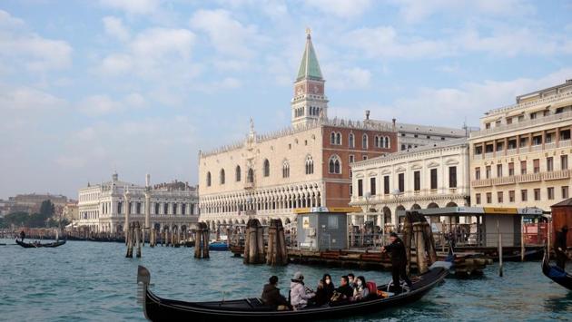 Tourists wearing protective masks are seen inside a gondola, after two coronavirus cases have been confirmed in Italy, in Venice, Italy. (REUTERS/Manuel Silvestri)