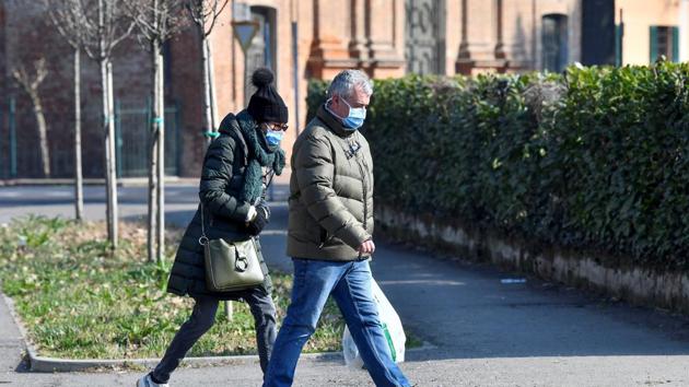 A man and a woman wearing face masks walk down a street amid a coronavirus outbreak in northern Italy, in Codogno, Italy. (REUTERS) A man and a woman wearing face masks walk down a street amid a coronavirus outbreak in northern Italy, in Codogno, Italy. (REUTERS)