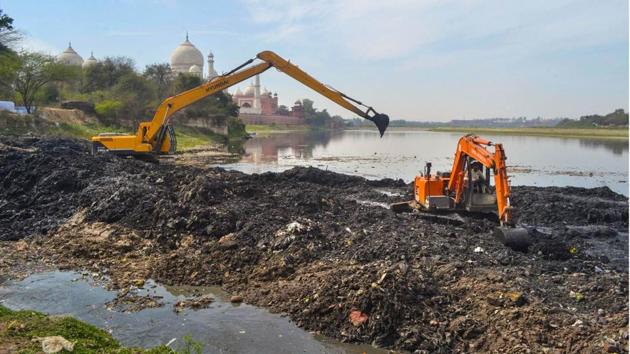 Earthmovers remove debris from the Yamuna river bed near Taj Mahal, ahead of the US President Donald Trump’s visit, in Agra, Uttar Pradesh. (PTI)