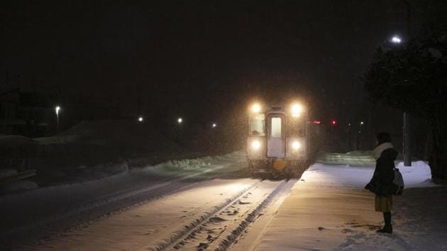 A woman stands on a snow-covered platform as a train approaches a station in Biei, central Hokkaido. Paul Sheehan, an Australian who has been coming to Japan for several years to build snow sculptures, noticed the difference this time in Sapporo’s Odori Park. (Jae C. Hong / AP)