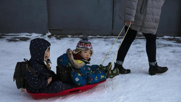 A mother pulls her children in a sled on an icy sidewalk. “We often have this kind of event,” Dr. Tomonori Sato, an associate professor at Hokkaido University, told The Associated Press. “However, the magnitude was abnormal. This maybe is because of warming temperatures.” (Jae C. Hong / AP)
