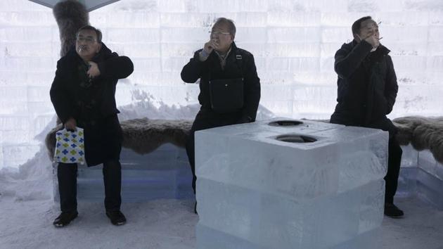 People smoke in a smoking room made with ice blocks at the annual Sapporo Snow Festival. Sato said there will be snow if Sapporo gets the Winter Olympics. But he could’t guarantee much snow 80 years from now. “Even if Sapporo gets snow, it will melt right away,” Sato said. “At the end of this century, it will be difficult maintain the snow festival.” (Jae C. Hong / AP)