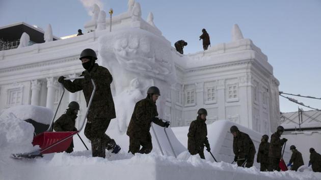 Self-Defense Force members remove fresh snow piled on a large snow sculpture of Poland's Palace on the Isle during the Sapporo Snow Festival. Sato predicts that Hokkaido, the island where Sapporo is located, will have more warming winters, which has to be a worry for an area that is officially bidding for the Winter Olympics. (Jae C. Hong / AP)
