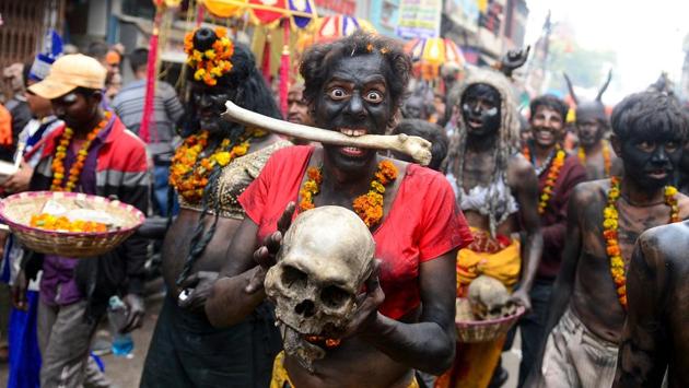 A Hindu devotee of Lord Shiva holds a human skull and bone while taking part in a religious procession to mark the Hindu festival of Maha Shivratri in Prayagraj, Uttar Pradesh. (Sanjay Kanojia / AFP)