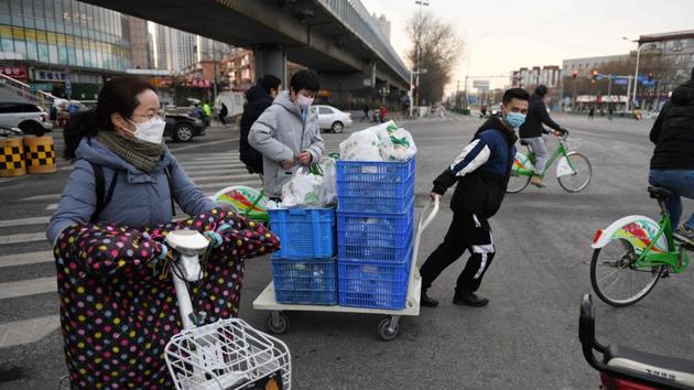 Yunhaiyao restaurant deliverymen out on the road. Zhao Yebule, store manager at Yunhaiyao’s Tongzhou branch in Beijing, said deliveries can rake in up to 6,000 yuan daily. But the company is still in a pinch. Li Jianying, a regional manager overseeing 10 outlets, said only around half of his staff were ready to resume work. Others cannot leave their residential compounds freely or face a 14-day quarantine when they return to Beijing. (Greg Baker / AFP)