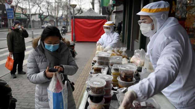 Restaurant workers sell food on the street outside their restaurant in Beijing, As it is, the big players are hurting. Lao Xiang Ji, which has some 800 outlets, estimates at least 500 million yuan in losses, said chairman Shu Cong Xuan in a video on the company’s WeChat account. Another major chain, Xibei Noodle Village, said on social media that it “cannot last for long” with tight cash flow. (Greg Baker / AFP)