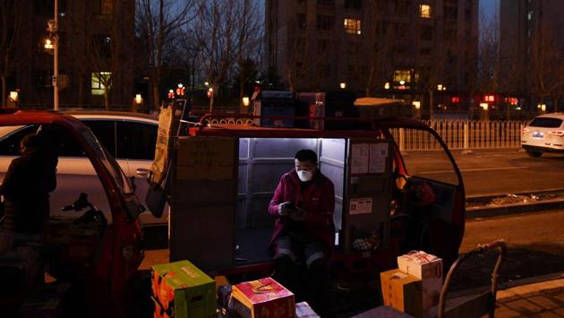 A delivery rider waits to deliver packages of food and other supplies outside a residential compound in Tongzhou, east of Beijing. Many restaurants have suspended dine-ins to help curb the spread of the virus, but eateries that have resumed operations remain largely empty, with people encouraged to stay home to avoid infections. COVID-19 has killed more than 2,400 in China and infected nearly 77,000. (Greg Baker / AFP)