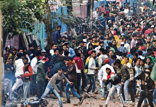 People throw stones during a clash between supporters of Citizenship Amendment Act (CAA) and those opposing it, at Maujpur, in New Delhi in Sunday.(Photo by Sonu Mehta / Hindustan Times)