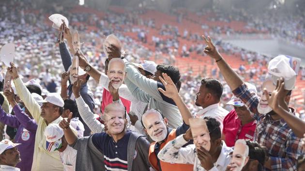 People wearing Prime Minister Narendra Modi and U.S. President Donald Trump’s mask wave as they arrive to attend the ‘Namaste Trump’ event at Sardar Patel Motera Stadium. (PTI)