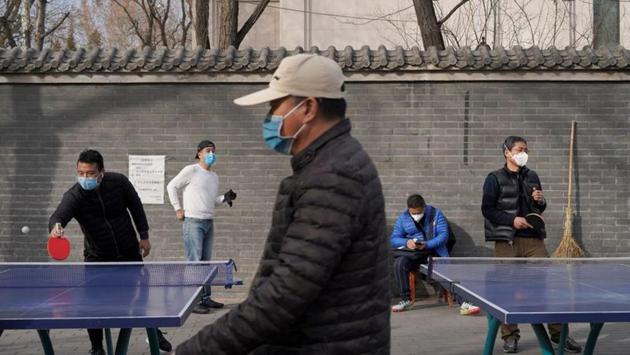 People wearing face masks play table tennis at a park, following an outbreak of the novel coronavirus in the country, in Beijing. Chinese stocks dropped the most in three weeks on Tuesday, as worries deepened a rapidly spreading coronavirus could become a global pandemic and deal a heavy blow to the global economic growth. (Stringer / REUTERS)