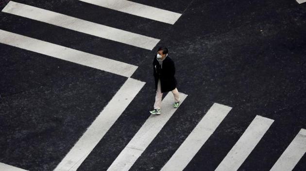 A man wearing a mask to prevent contracting the coronavirus walks on a zebra crossing in Seoul. South Korea reported 231 new cases, taking its total to 833. Many are in its fourth-largest city, Daegu, which became more isolated with Asiana Airlines and Korean Air suspending flights there until next month. (Kim Hong-Ji / REUTERS)