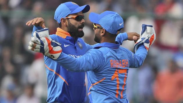 Virat Kohli, left, celebrates the dismissal of Australia's Peter Handscomb with teammate Rishabh Pant.(AP)