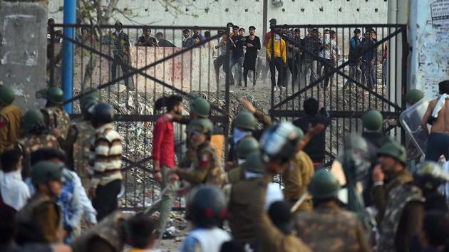 Protesters hurl stones at police personnel during violent clashes between anti- and pro-CAA demonstrations, at Jaffarabad in New Delhi on Monday.(Raj K Raj/HT Photo)